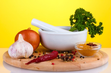 White mortar and pestle with spice on yellow backgroundの写真素材