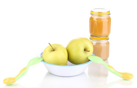 Jars of baby puree with plate, spoon and fork isolated on whiteの写真素材