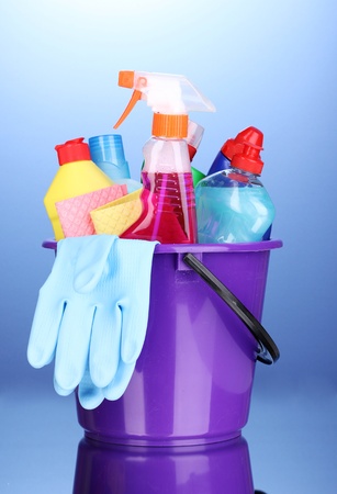Bucket with cleaning items on blue backgroundの写真素材