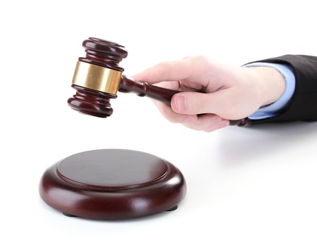 wooden gavel in hand isolated on whiteの写真素材