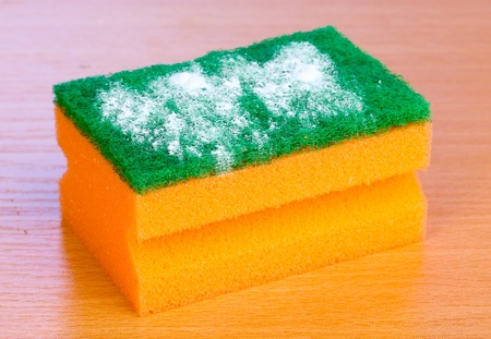 Sponge with scouring powder on wooden table on blue backgroundの写真素材