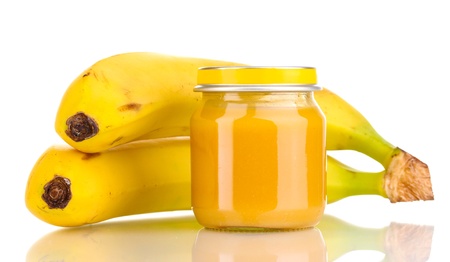 Jar of baby puree and bananas isolated on whiteの写真素材