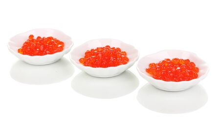 Red caviar in white bowls isolated on whiteの写真素材