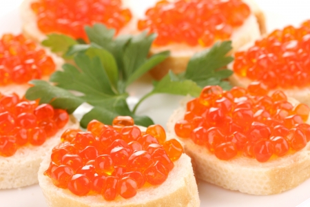 Red caviar on bread on white plate close-upの写真素材