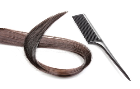 Shiny brown hair and comb isolated on whiteの写真素材