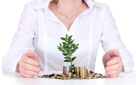 Woman hands with coins and plantの写真素材
