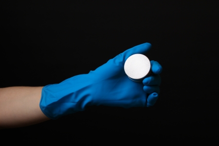 Uranium in hand isolated on black