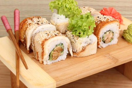 Tasty rolls served on wooden plate on wooden backgroundの写真素材