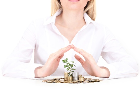 Woman hands with coins and plant isolated on whiteの写真素材