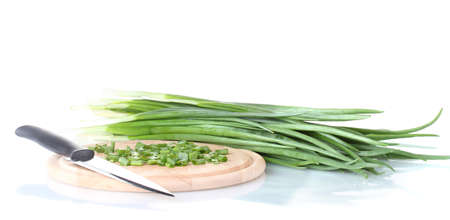 Green onion on a cutting board with knife isolated on whiteの写真素材