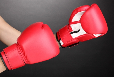 Red boxing gloves on hands on grey backgroundの写真素材