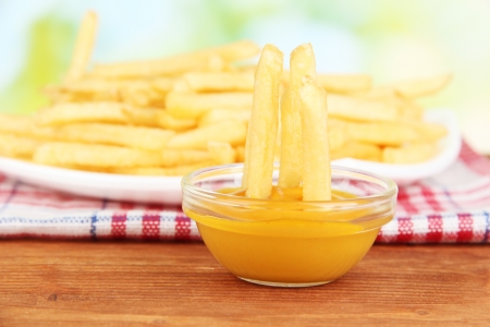 Potatoes fries on the plate with sauce on wooden background close-upの写真素材