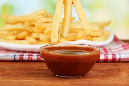 Potatoes fries on the plate with sauce on wooden background close-upの写真素材