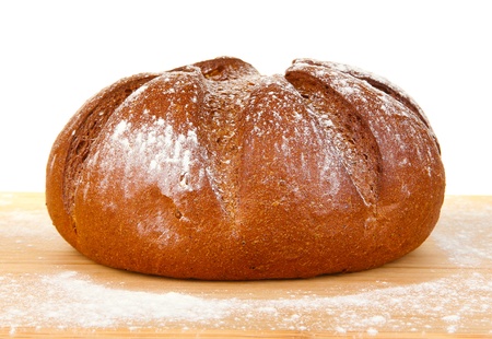 Homemade whole bread on wooden cutting board close-up
