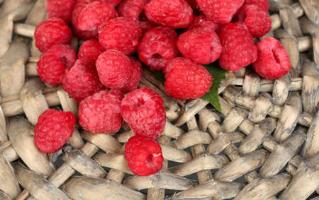 Fresh raspberries on wicker mat close-up