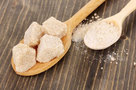 Brown sugar in spoons on wooden backgroundの写真素材