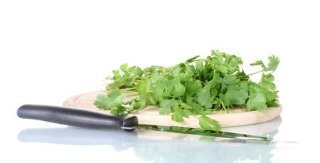 Coriander on a cutting board with knife isolated on whiteの写真素材