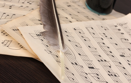 Musical notes and feather on wooden tableの写真素材
