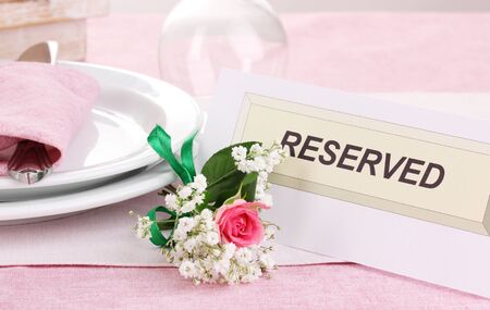 Table setting with reserved card in restaurantの写真素材