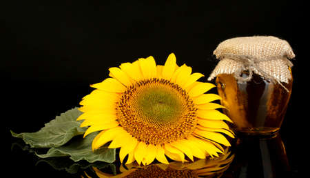sunflower oil and sunflower isolated on blackの写真素材