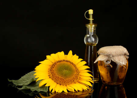 sunflower oil and sunflower isolated on blackの写真素材