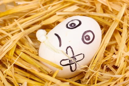 White egg with funny face in strawの写真素材