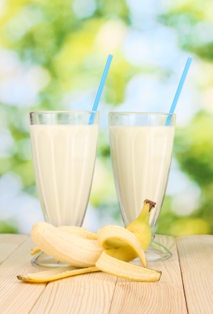 Banana milk shakes on wooden table on bright backgroundの写真素材