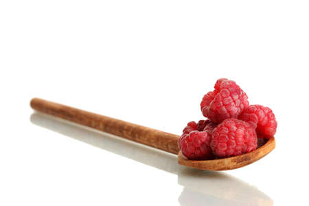 ripe raspberries in wooden spoon isolated on whiteの写真素材