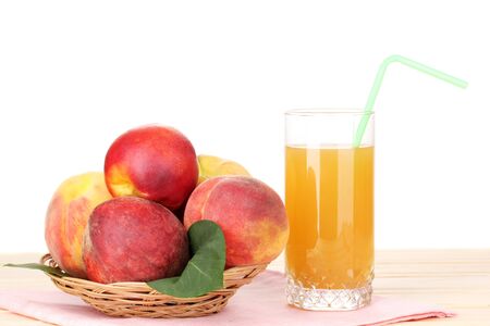 Ripe peaches and juice on wooden table on white backgroundの写真素材