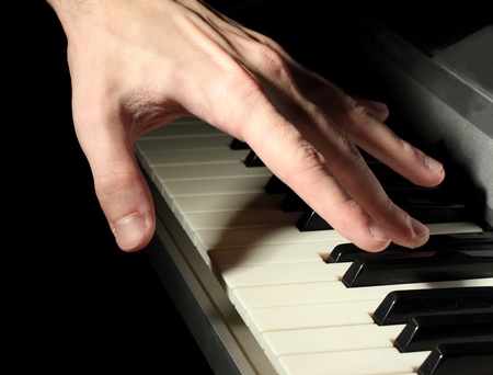 hand of man playing piano