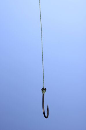 Single fish hook on blue background