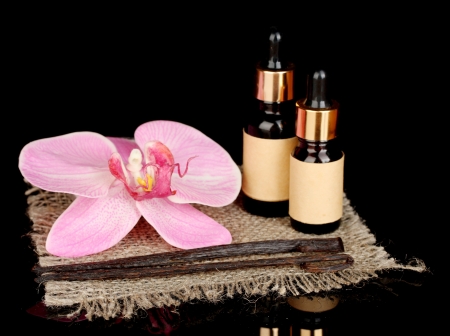 Vanilla pods with essential oil isolated on blackの写真素材