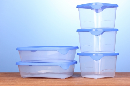 Plastic containers for food on wooden table on blue backgroundの写真素材