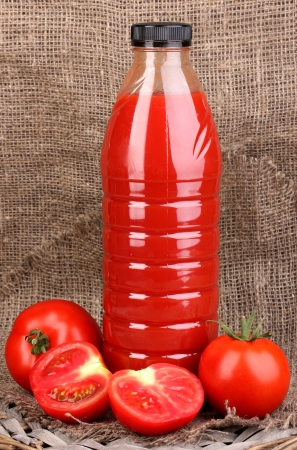 Tomato juice in bottle on sackcloth backgroundの写真素材