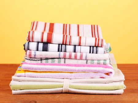 kitchen towels on wooden table on orange background close-upの写真素材