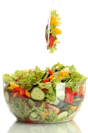 fresh vegetable salad in transparent bowl with spoon and fork isolated on whiteの写真素材