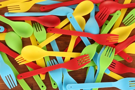 bright plastic disposable tableware on wooden background close-upの写真素材