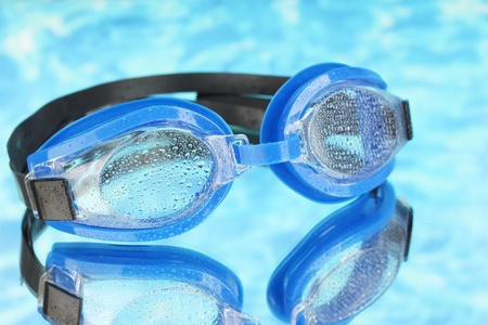 blue swim goggles with drops on blue sea backgroundの写真素材