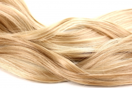 Curly blond hair close-up isolated on whiteの写真素材