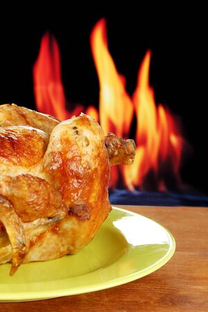 Roasted whole chicken on a green plate on wooden background close-upの写真素材