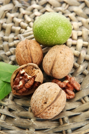 walnuts with green leaves, on  wicker backgroundの写真素材