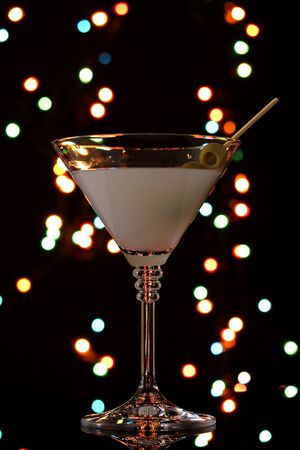 Martini glass and olives on dark bright backgroundの写真素材