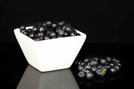 Tasty blueberries in white bowl isolated on black close-upの写真素材