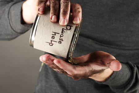 homeless pours money from bank, close-upの写真素材
