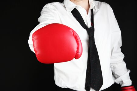 businessman in boxing gloves isolated on blackの写真素材