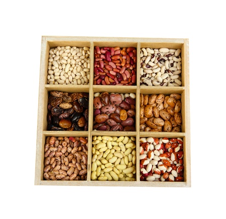 Diverse beans in wooden box sections isolated on whiteの写真素材