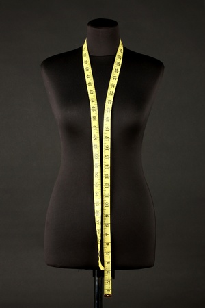empty black mannequin with measuring tape isolated on blackの写真素材