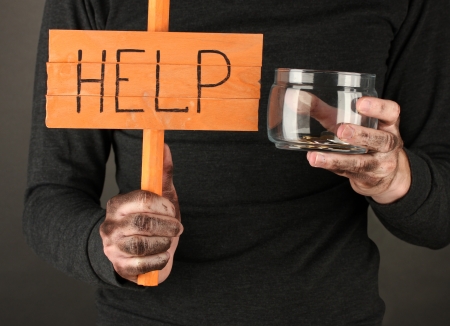 homeless man asks for help, on black background close-upの写真素材