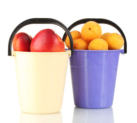 Ripe fruit in plastic buckets isolated on whiteの写真素材