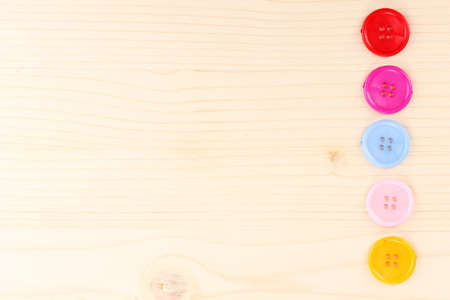 Colorful sewing buttons on wooden backgroundの写真素材